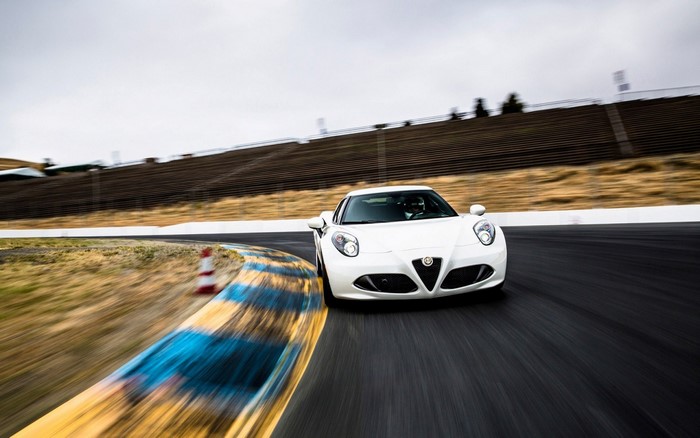 White Alfa Romeo 4C driving on a race track