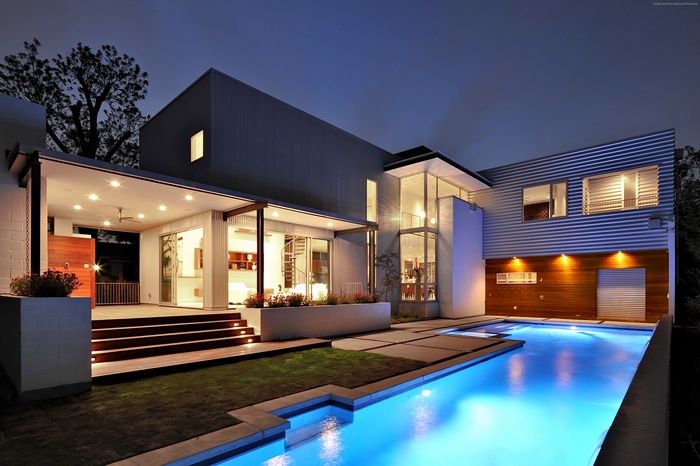 Modern mansion with a swimming pool at night