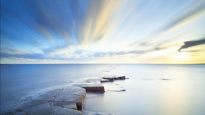 Long exposure of sea and sky with rocky shore