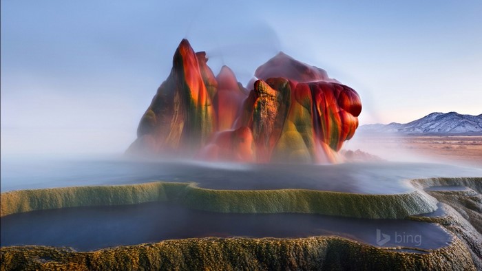 Fly Geyser in Nevada with mist and mountains