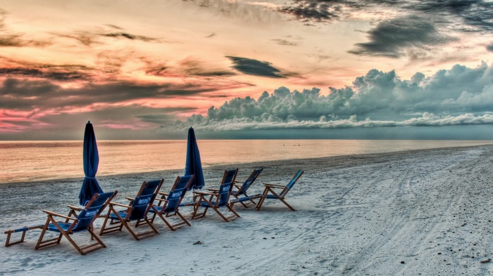 Beach chairs and umbrellas at sunset