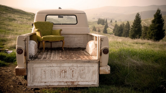 Old Dodge truck with armchair in a grassy field