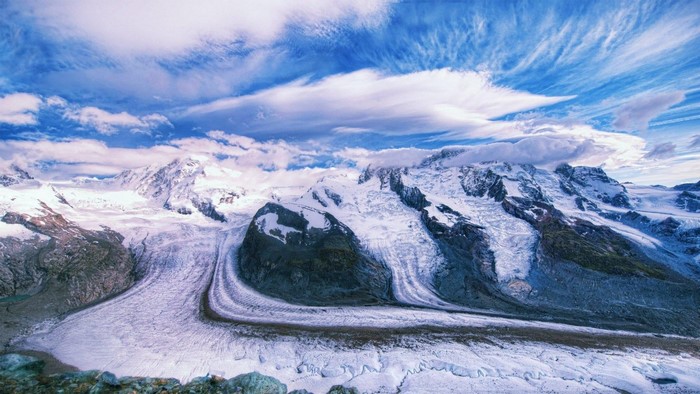 Snow-covered mountains and glaciers under a cloudy sky