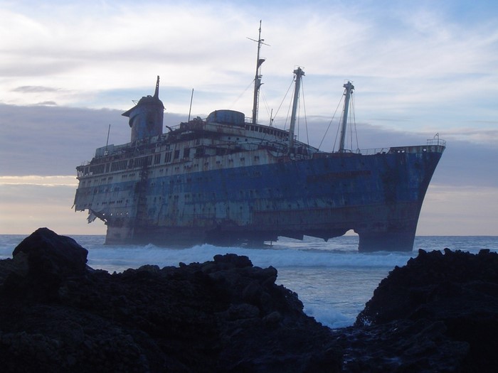 Abandoned shipwreck on a rocky coast at dusk