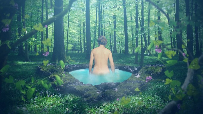 Person bathing in a forest pool