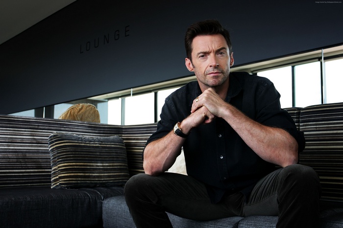 Hugh Jackman sitting on a sofa in a lounge