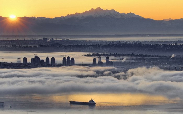 Vancouver cityscape at sunrise with mountains and fog