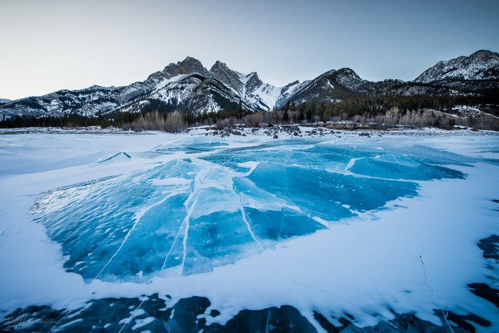 Cracked Ice on Frozen Lake with Snow-Capped Mountains