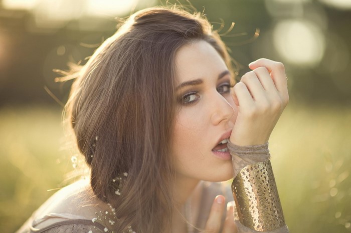 Woman with brown hair and golden cuff