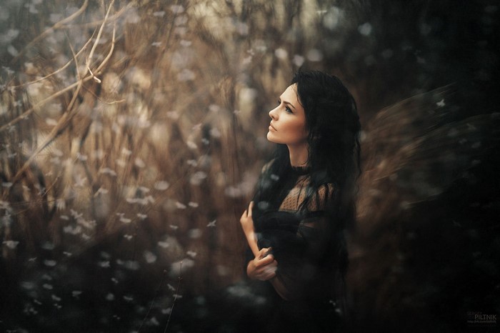 Woman in black dress in a dark forest