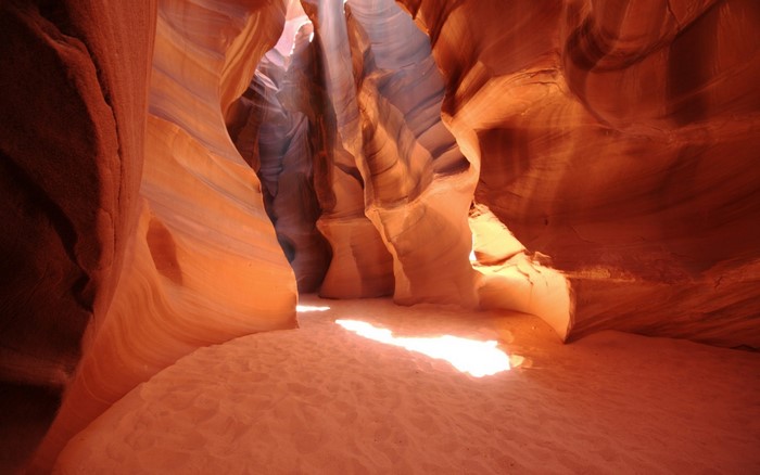 Sunlight beams into a sandstone slot canyon