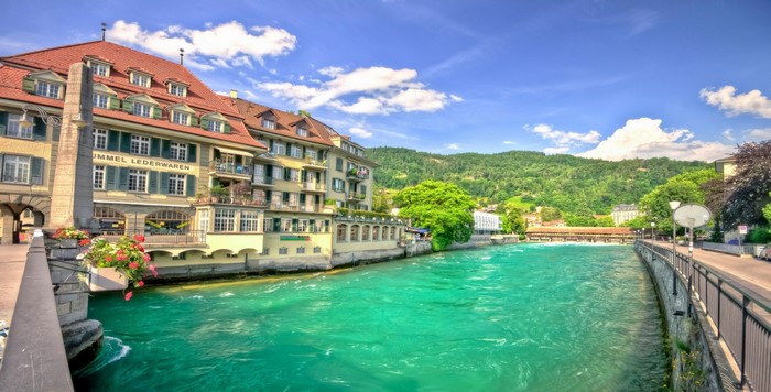 Riverfront buildings and a wooden bridge in Switzerland