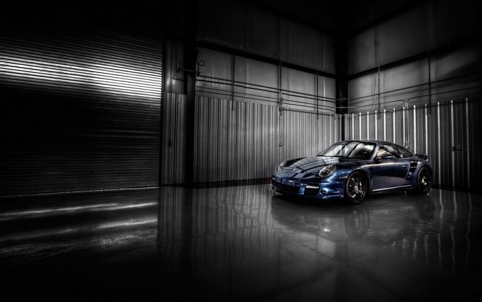 Blue Porsche 911 Turbo in a dark garage