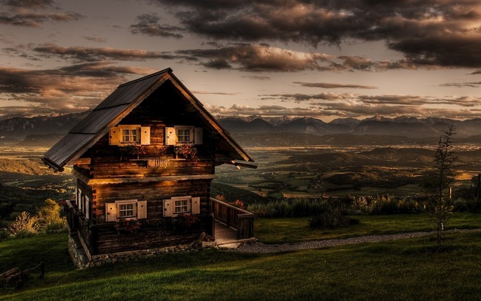 Wooden house on a hill overlooking a valley at sunset