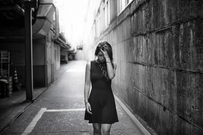 Woman in black dress in alleyway