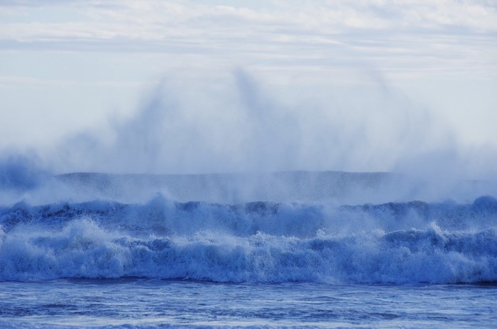 Ocean waves crashing with mist and clouds