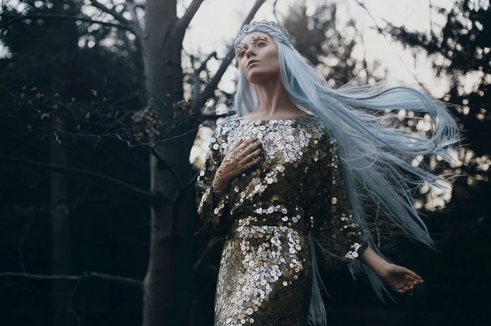 Woman with blue hair in sequined dress and crown