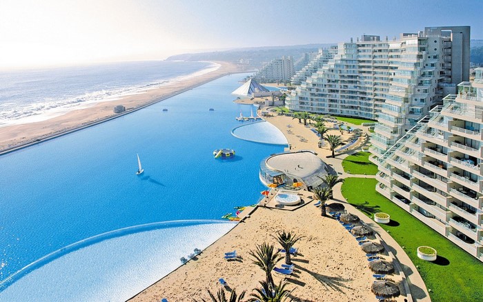 Aerial view of a large resort with a long swimming pool and beach in Chile