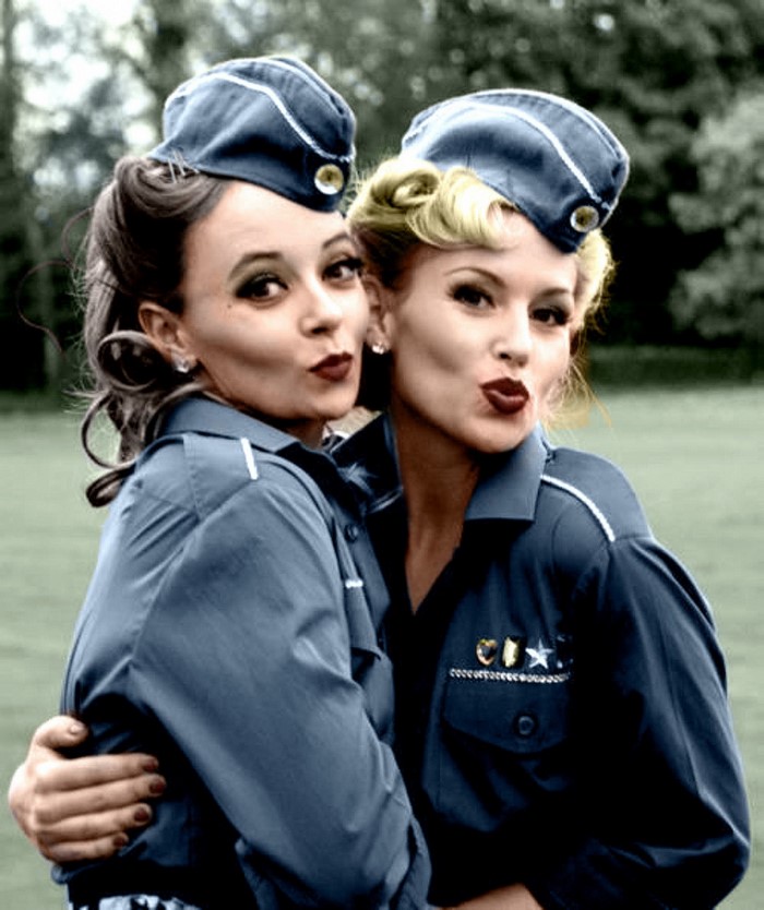 Two women in vintage military uniforms posing
