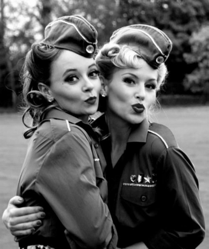 Two women in vintage military-style uniforms posing