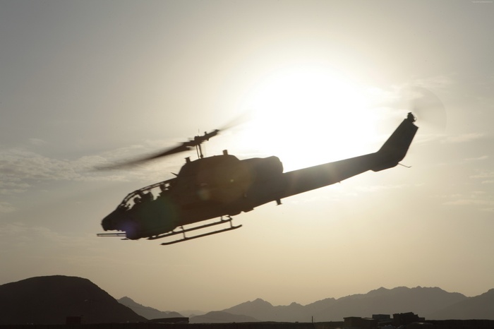 AH-1W Super Cobra helicopter in flight at sunset