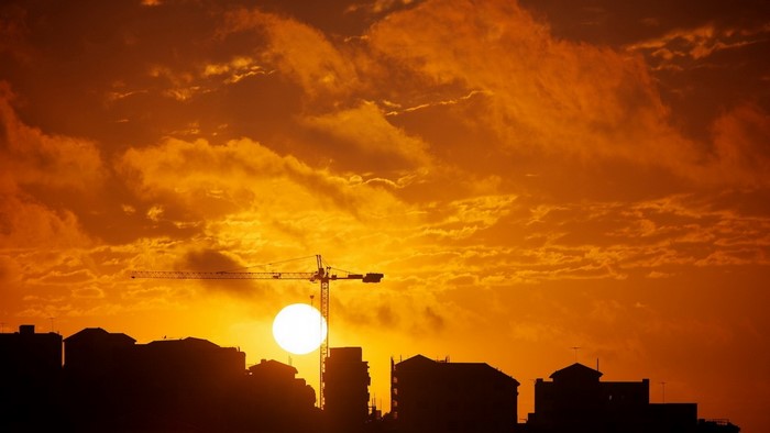 Sunset over cityscape with construction crane