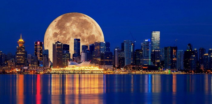 Vancouver skyline with a large moon over the water