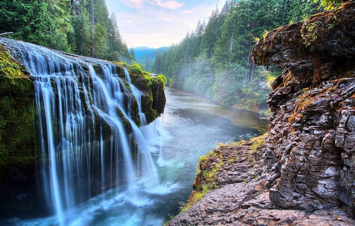 Waterfall flowing into a river in a forest