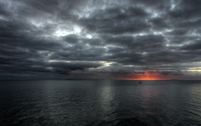 Boat on the sea during a stormy sunset