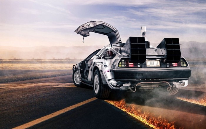 DeLorean time machine driving on a road with flames