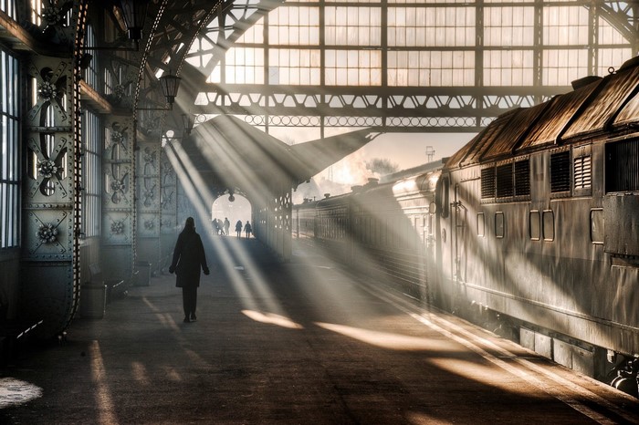 Train station with sunbeams and a lone figure