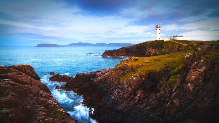 Lighthouse on a rocky coast at dusk