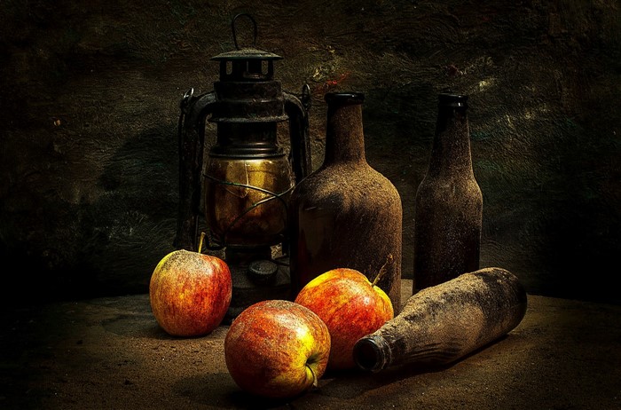 Still life painting of apples, bottles, and a lantern