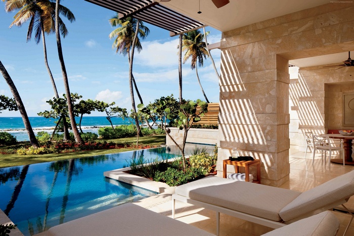 Luxury resort pool with palm trees and ocean view in Puerto Rico