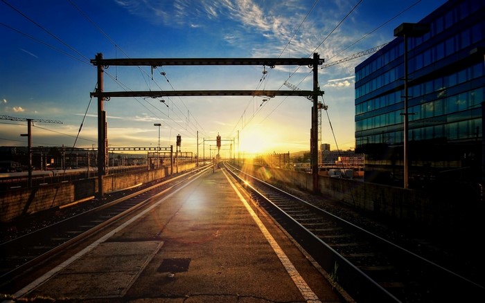 Train tracks at sunset with city buildings