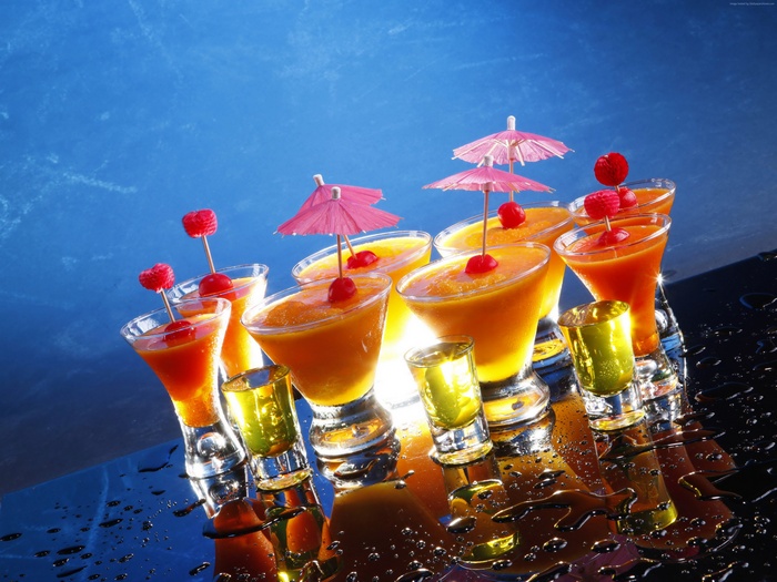 Assortment of colorful cocktails and shots with garnishes