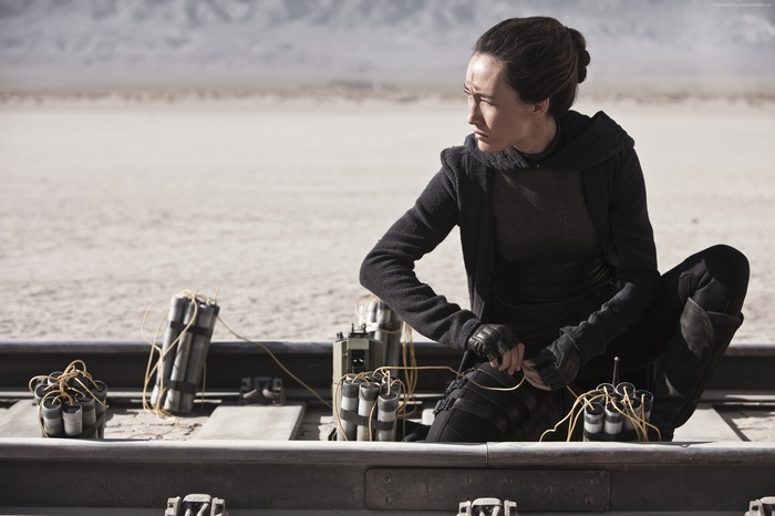 Maggie Q as Nikita on train tracks with explosives