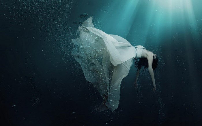 Woman in white dress underwater