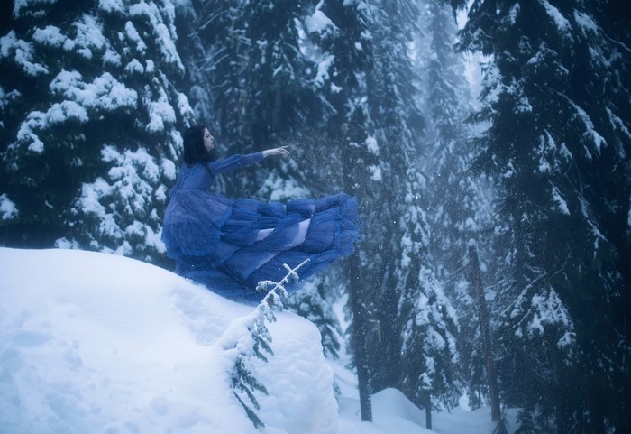 Woman in blue dress in snowy forest