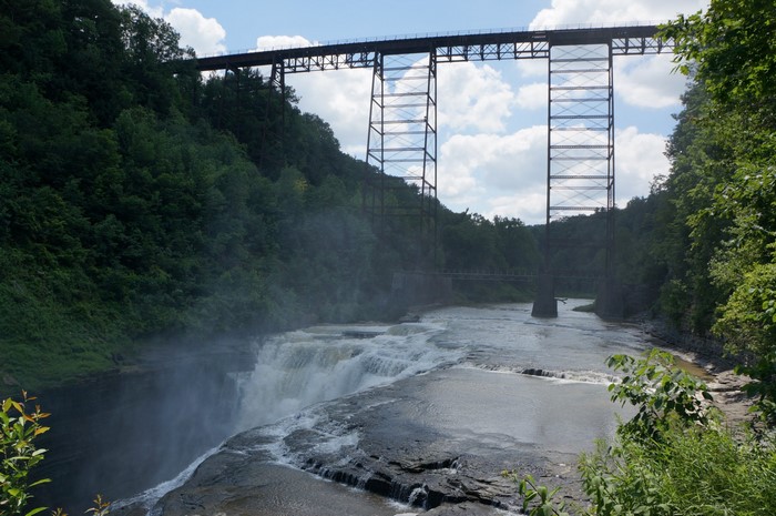 Waterfall and a large metal bridge over a river