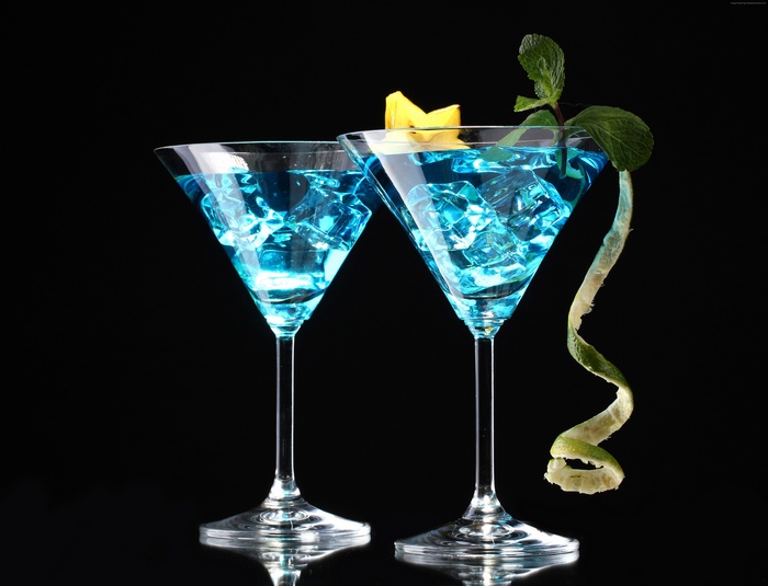 Two blue cocktails with ice and mint garnish