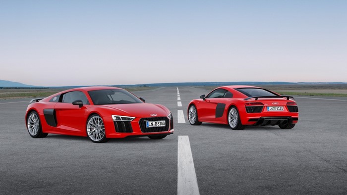 Two red Audi R8 sports cars on a road