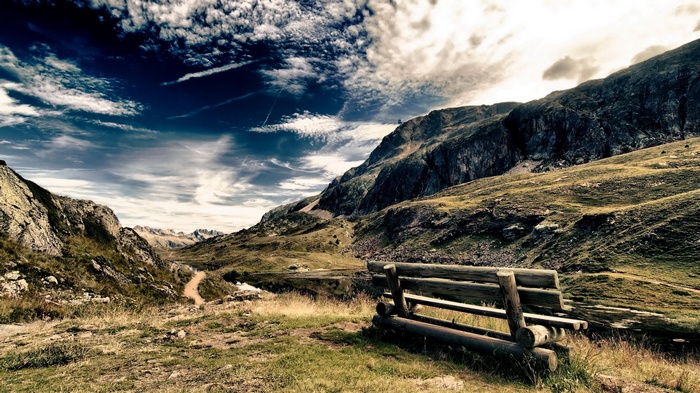 Wooden bench overlooking a mountain valley with a lake