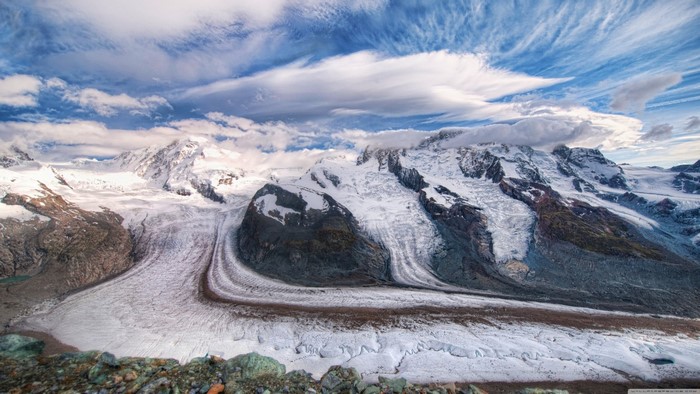 Snow-covered mountains and glaciers under a cloudy sky