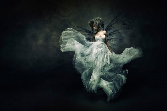 Woman with dark wings in a white dress