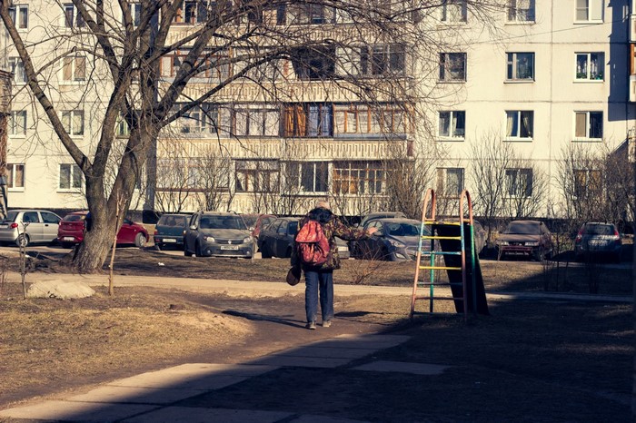 Person with backpack walking in a residential area