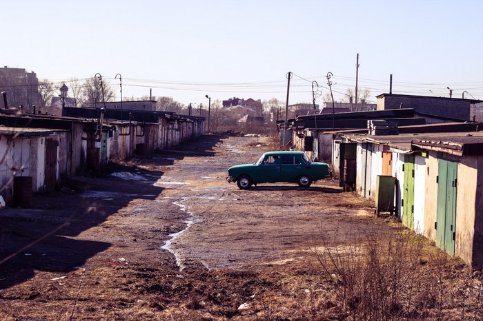 Green Moskvich car parked in a row of garages