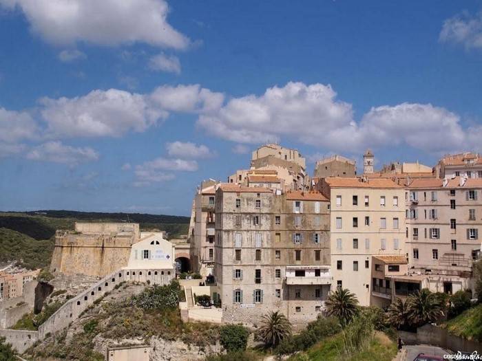 Cliffside town with ancient fortress under a blue sky