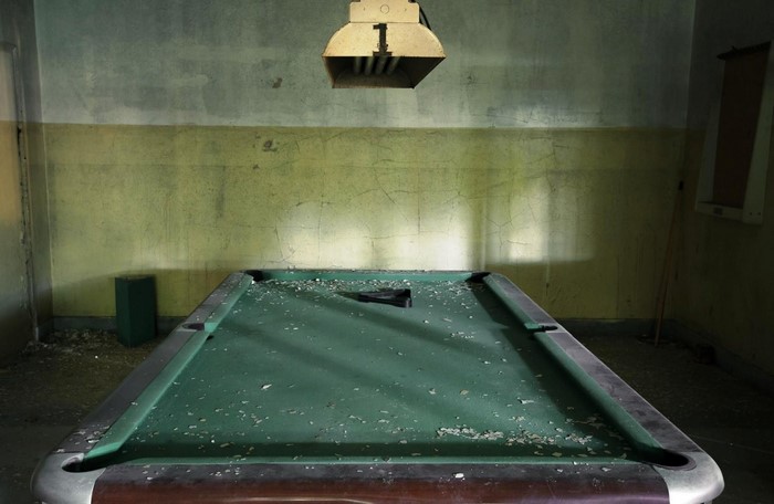 Abandoned pool table with overhead light