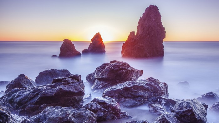 Rocky coast at sunset with calm sea